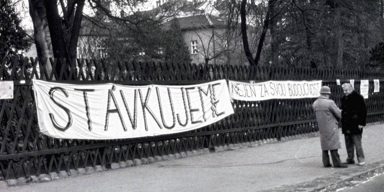 Transparent na plotě areálu přírodovědecké fakulty v době Sametové revoluce. 
