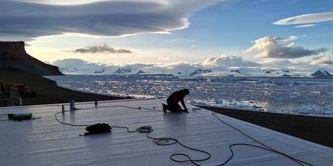 Pokrývač Dimitris Georgiadis pracuje na střeše polární stanice. 