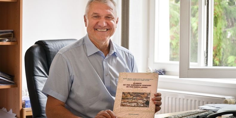 Profesor Rudolf Brázdil s publikací oceněnou rektorem MU.