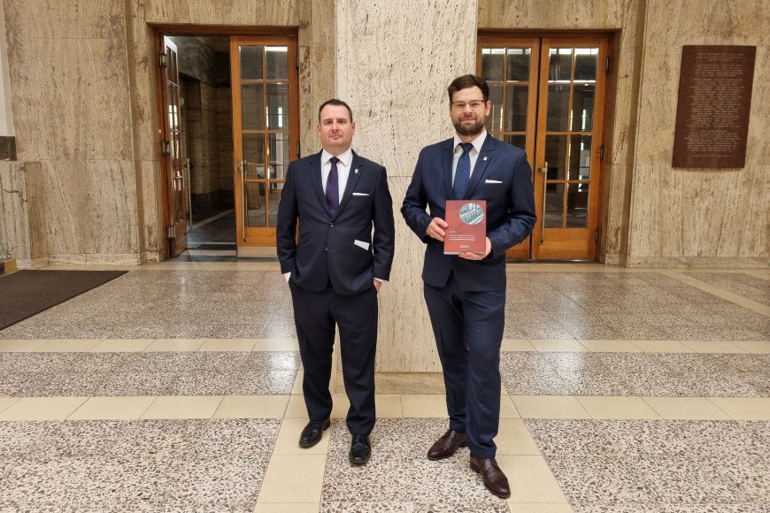 Foto: Sabina Hauserová Dosud nezpracované téma historie právnických sjezdů je důležitou publikací, kterou na fotografii prezentují Jaromír Tauchen a Jan Kabát z Katedry dějin státu a práva.