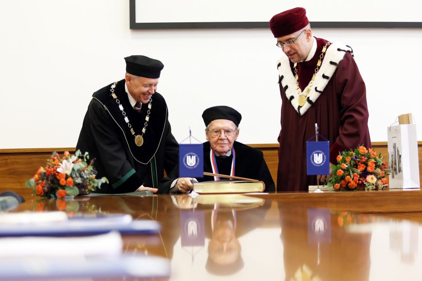 Demetz při zápisu do pamětní knihy Masarykovy univerzity. Vlevo prorektor Rabušic, vpravo rektor Bek.